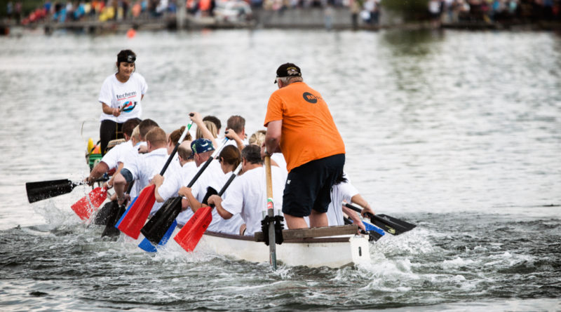 Drachenbootrennen - Padel stechen in das Wasser. Wasserstritzt hoch